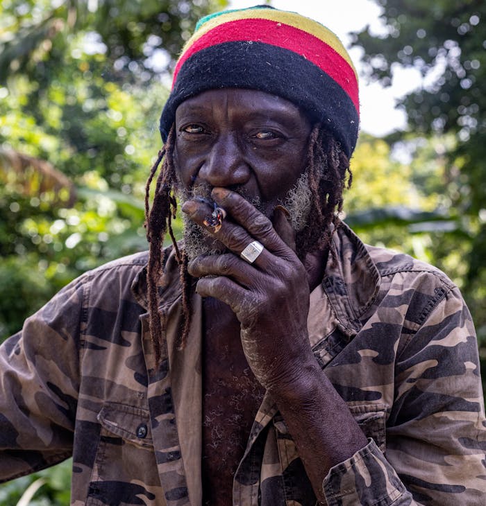 about-us Portrait of a Rastafarian man smoking outdoors in Seaforth, Jamaica.