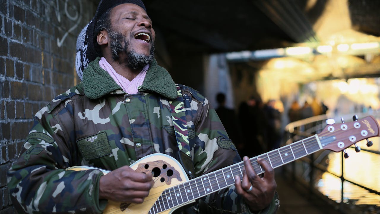 heros-img Musician performing passionately on a street with a guitar, capturing the essence of urban life in London.