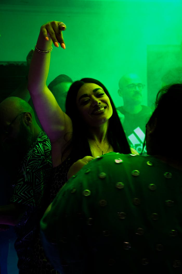 Joyful moment captured at a party in Tabriz, with people dancing under colorful lights.